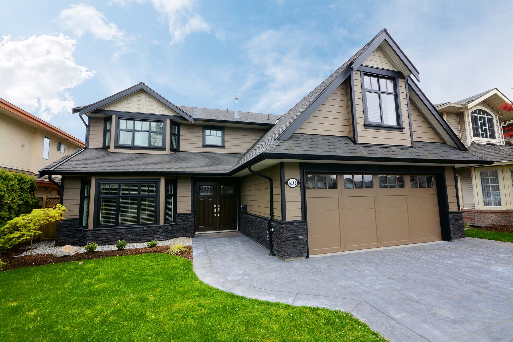West Coast Home Projects team standing outside a modern custom home in Delta, BC