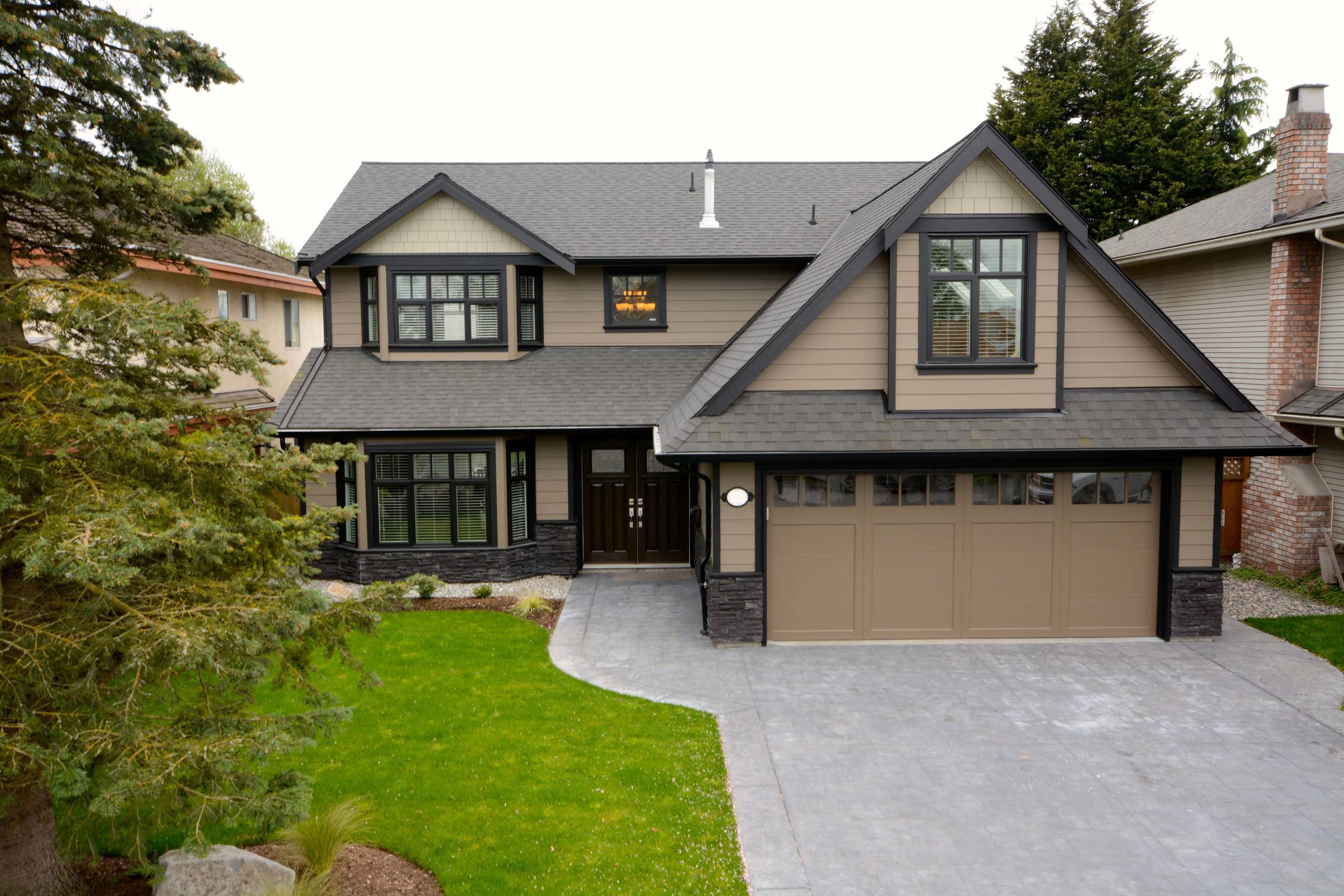West Coast Home Projects team standing outside a modern custom home in Delta, BC