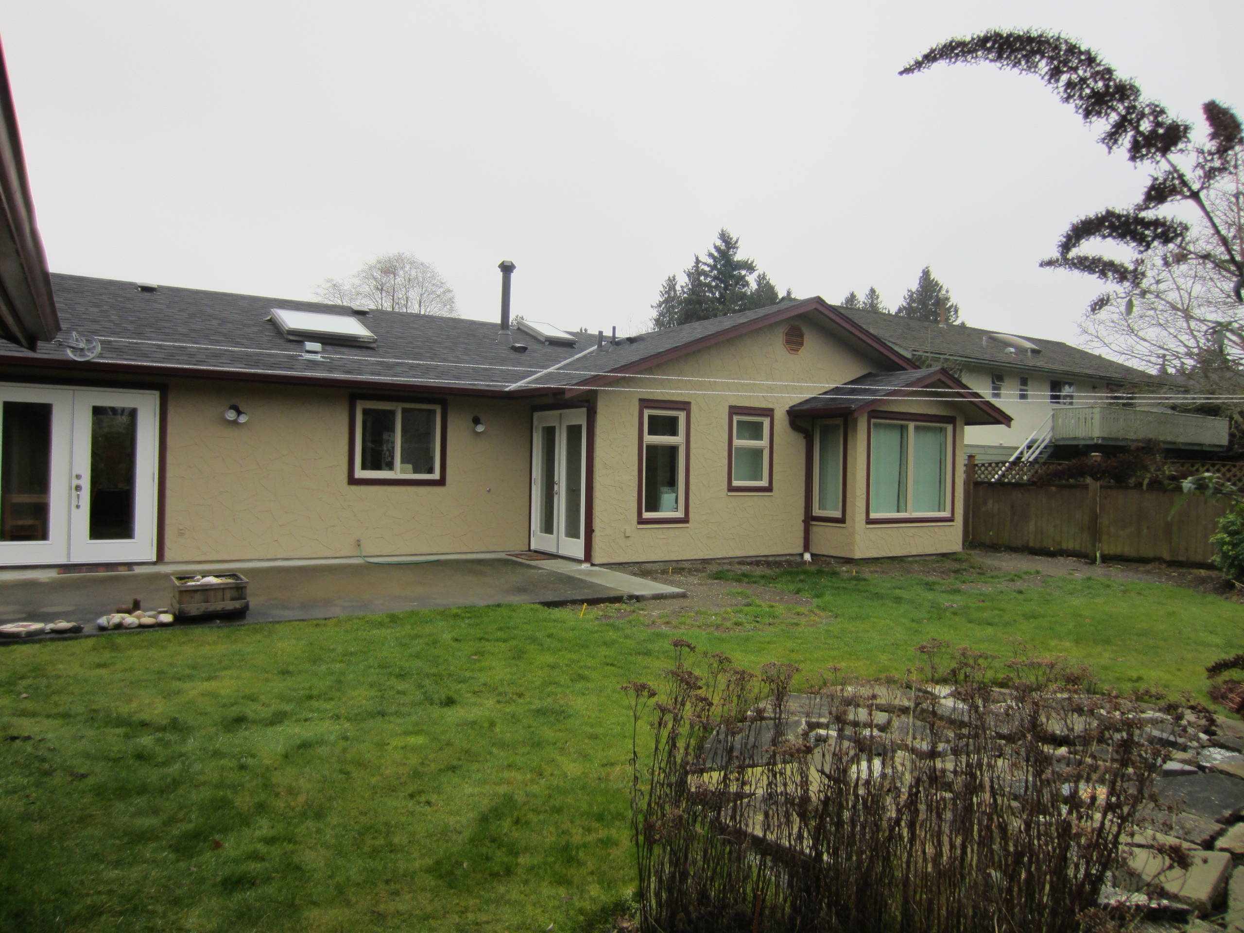West Coast Home Projects team standing outside a modern custom home in Delta, BC